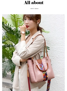 Pink crocodile-embossed bucket bag detail with colorful woven strap and brown handle