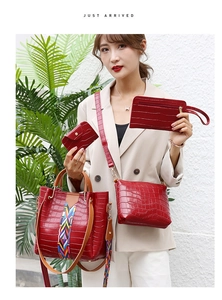 Detail view of red crocodile pattern 4-piece handbag set with vibrant woven strap