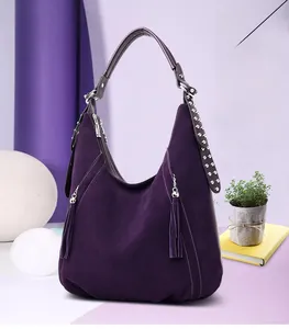 Detail of purple faux suede hobo bag with fringe tassels and silver metal rivets