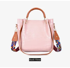 Back view of pink crocodile pattern bucket bag with colorful woven shoulder strap