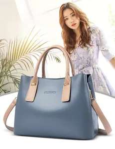 Dettaglio del logo ALLFANCY su una borsa blu con manici e tracolla color crema