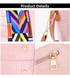Detail view of pink crocodile pattern bucket bag with colorful woven wide shoulder strap