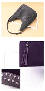 Detail of matte leather shoulder bag with long tassel and metallic stud accents