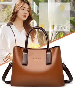 Dettaglio del logo ALLFANCY dorato e degli accessori su questa borsa in pelle marrone