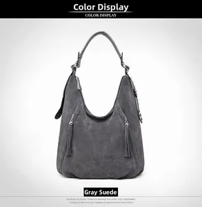 Detail of dark grey hobo bag with tassel zippers and metal stud strap accents