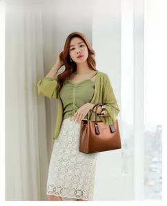 Borsa tote in pelle lucida marrone con cardigan verde per un look da ufficio elegante