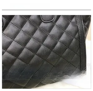 Gros plan sur la texture en cuir noir matelassé avec motif à carreaux du sac à main