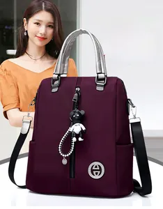 Détail du sac à dos bordeaux polyvalent avec zip en métal et charm d'ours mignon