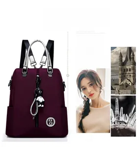 Détail du sac à dos en tissu Oxford violet avec poignée argentée et pendentif ours