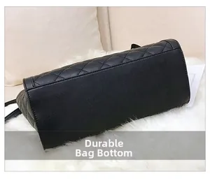 Détail de la base renforcée résistante à l'usure d'un sac à main en cuir matelassé noir