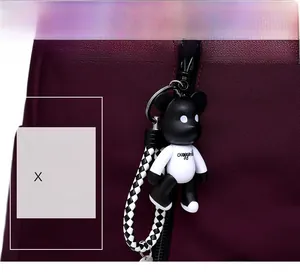 Détail du sac à dos en nylon bordeaux avec un charm ours tendance en noir et blanc