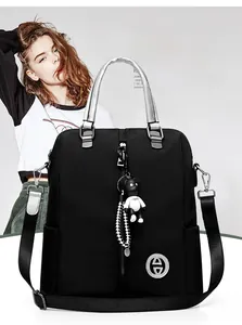 Détail d'un sac à dos noir polyvalent avec pendentif ours et lanière en damier chic