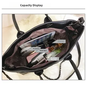 Détail montrant la grande capacité du sac cabas matelassé noir avec objets du quotidien
