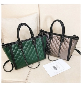 Détail de grands sacs fourre-tout matelassés vert et champagne avec bandoulières
