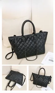 Détail du sac cabas matelassé noir avec bandoulière chaîne et motif à losanges chic