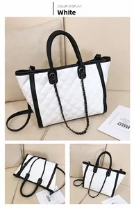 Détail du sac cabas matelassé blanc avec anses en chaîne noire et surpiqûres contrastées