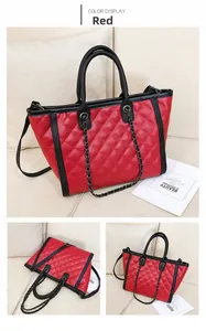 Détail du grand sac cabas rouge matelassé avec bordures noires et bandoulière chaîne