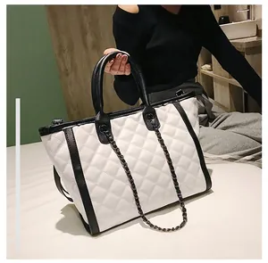 Détail des coutures matelassées et contraste noir et blanc sur le grand sac cabas