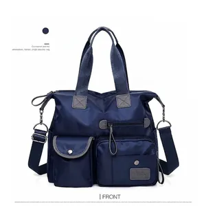 Blue waterproof nylon travel handbag with multiple pockets and detachable shoulder strap