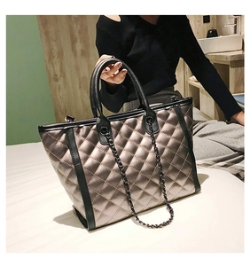 Vue détaillée du grand sac cabas matelassé doré avec poignées noires et chaîne en métal