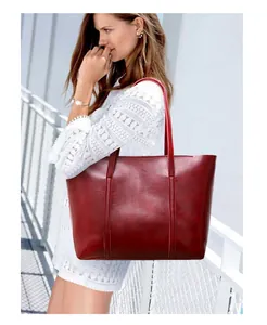 Vue détaillée d'un sac cabas rétro rouge vin fini brillant porté par un mannequin en blanc