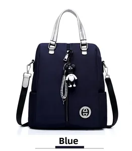 Détail du sac à dos bleu foncé imperméable avec poignées argentées et porte-clés panda