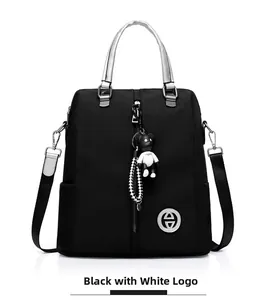 Détail du sac à dos polyvalent noir avec insigne métallique et charm d'ours mignon