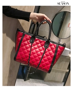 Détail du sac cabas rouge matelassé avec bordures noires et chaîne métallique