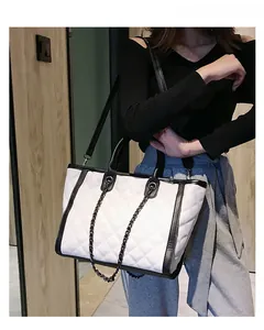 Vue portée du grand sac cabas matelassé blanc avec bordures noires et chaîne