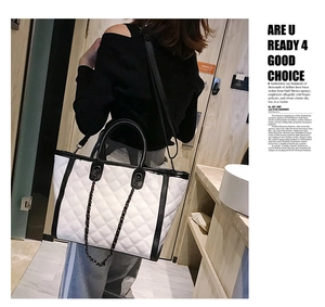 Détail des coutures matelassées et de la chaîne noire sur ce sac cabas blanc