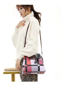 Detail of geometric pattern tote bag with luxury pom-pom charm and leather strap