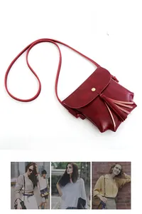 Détail du sac bandoulière bordeaux vintage avec boucle magnétique dorée et pompon frangé
