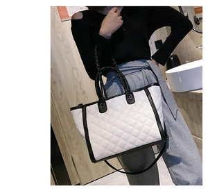 Détail du grand sac cabas blanc matelassé avec bordure noire et anses en chaîne