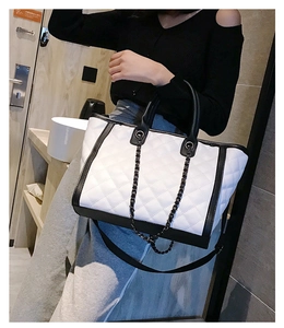 Détail du sac cabas matelassé noir et blanc avec chaîne en métal et bandoulière longue