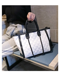 Détail du sac cabas matelassé avec surpiqûres noires et blanches et chaîne métallique