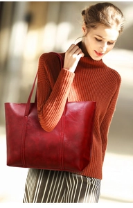Vue latérale du grand sac cabas rouge foncé en cuir brillant avec doubles bretelles