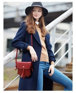 Détail d'un sac bandoulière rouge mat avec franges et fermoir magnétique doré
