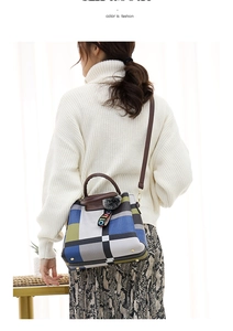Detailed view of colorful patchwork handbag with leather straps and decorative charm