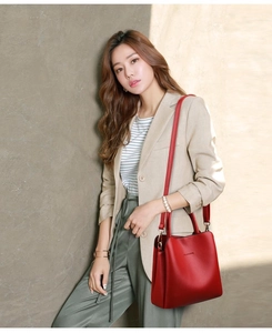 Red pebbled leather handbag with Classic logo shown on a model in beige blazer