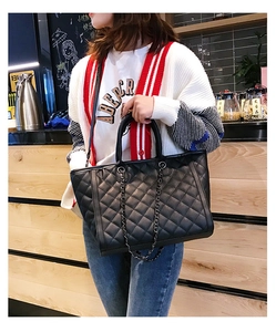 Détail du grand sac cabas noir matelassé avec bandoulière chaîne en cuir brillant