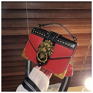 Details der rot-schwarzen Ledertasche mit goldener Löwenkopf-Schnalle und Nieten