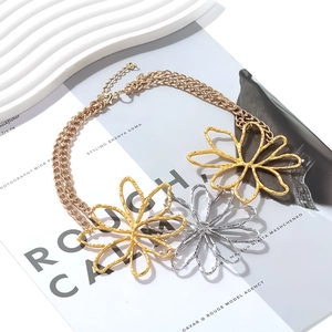 Detail view of layered alloy necklace featuring textured gold and silver hollow flower charms