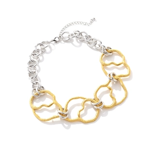 Vue détaillée du collier à grosse chaîne bicolore avec anneaux dorés à texture martelée