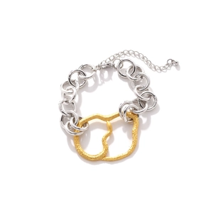 Détail du bracelet chaîne à gros maillons avec anneaux dorés entrelacés et texture martelée