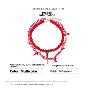 Detailed specs of layered beaded necklace with strawberry, chili and carrot charms