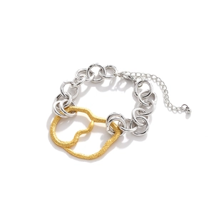 Détail macro de maillons de chaîne épais en métal mixte avec pendentif doré texturé
