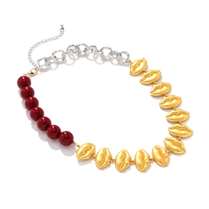 Detail of lobster clasp and adjustable chain on gold lip and burgundy bead necklace