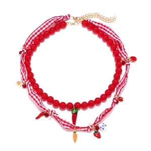 Double-layered beaded necklace with strawberry, chili, and flower pendants on white background