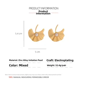 Detailed view of gold ginkgo leaf earrings with pearl accents and size measurements