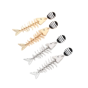 Detail of gold and silver fishbone drop earrings with striped oval studs in macro view
